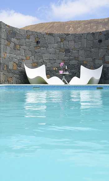 Pool with lounge area Pool with volcanic stone wall at Alisios Hipoclub Villa